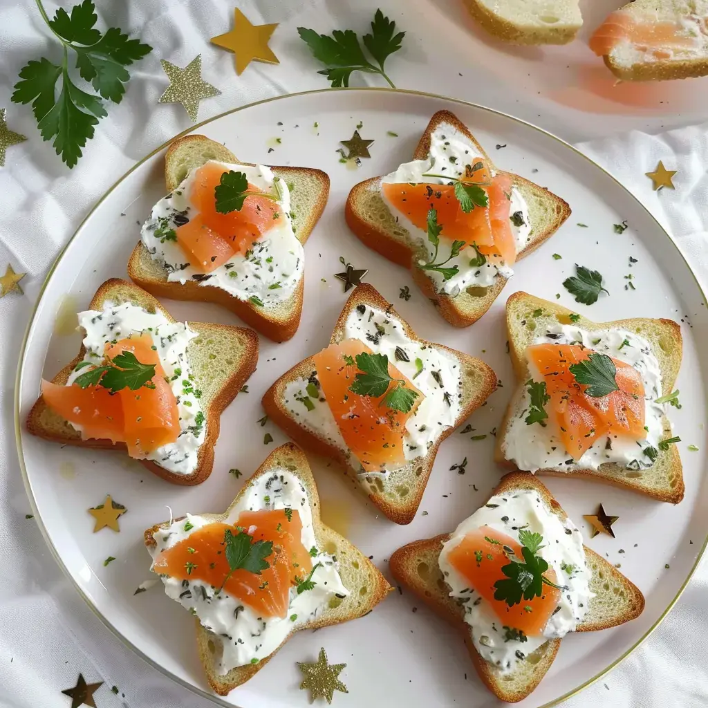 Pain découpé en étoiles avec fromage frais, saumon et herbes posé sur une assiette décorée d’étoiles dorées